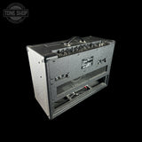Guitar amplifier with control knobs and speaker on a black background, featuring 'Tone Shop' logo.