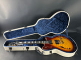 Electric guitar in an open case on a gray background