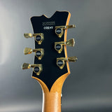 Guitar headstock with tuning pegs on a gray background