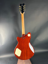 Wooden electric guitar on a reflective gray surface