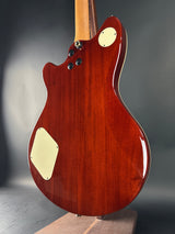 Close-up of a wooden electric guitar body with a dark gray background
