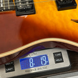 Guitar on a digital scale displaying weight
