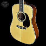 Acoustic guitar with a visible brand logo on a black background