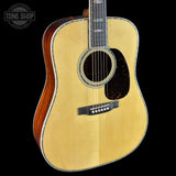 Acoustic guitar with a visible brand logo on a black background