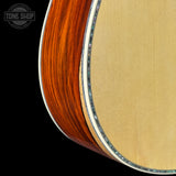 Close-up of a guitar's soundhole and body with 'Tone Shop' logo.