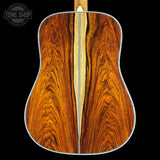Close-up of a wooden acoustic guitar back with 'Tone Shop' logo.