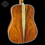 Close-up of a wooden acoustic guitar back with 'Tone Shop' logo.