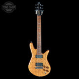 Electric guitar with a natural wood finish on a black background, featuring the Tone Shop logo.