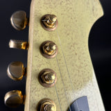 Close-up of a guitar's headstock with tuning pegs.