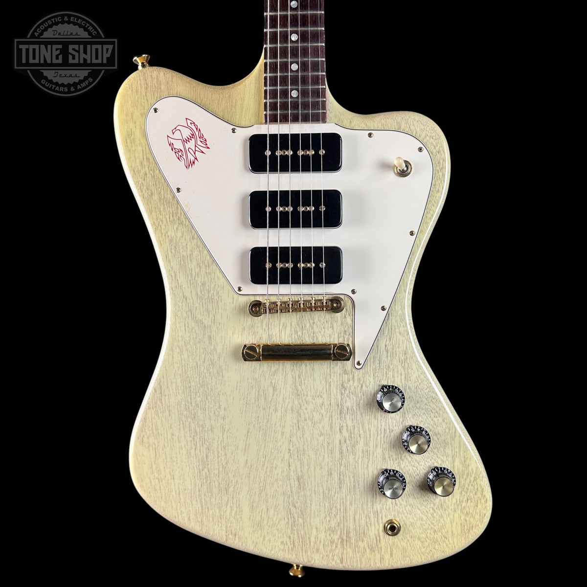 White electric guitar with a distinctive design on a black background