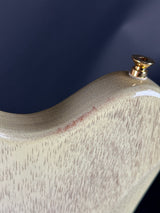 Close-up of a wooden handle with a gold knob on a dark background