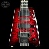 Red electric guitar with a black background, featuring the brand 'Tone Shop'.