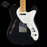 Black and white electric guitar with a visible brand logo in the corner.