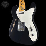Black and white electric guitar with a visible brand logo in the corner.