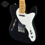 Black electric guitar with white pickguard on a black background, featuring 'Tone Shop' logo.