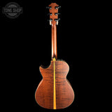 Back view of a wooden acoustic guitar with a visible brand logo in the corner.