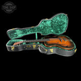 Vintage guitar in a green and black case with 'Tone Shop' logo.