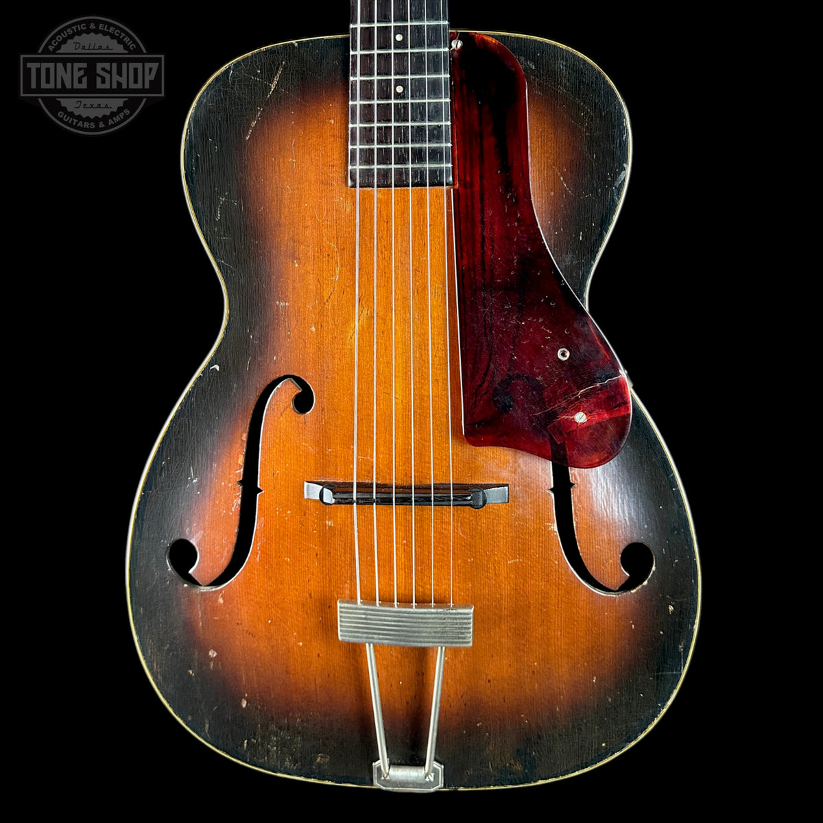 Vintage acoustic guitar with a dark brown finish on a black background, featuring the 'Tone Shop' logo.