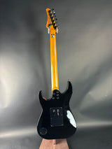 Electric guitar with a black pickguard and blonde neck on a gray background