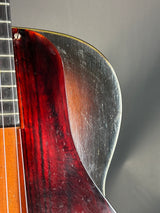 Close-up of a guitar's neck and headstock with a blurred background