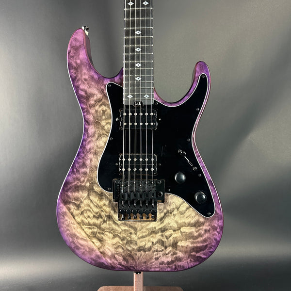 Electric guitar with a purple and black gradient on a gray background