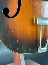 Close-up of a wooden string instrument, likely a mandolin or guitar, with a focus on the soundhole.