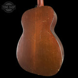 Back of a wooden acoustic guitar with 'Tone Shop' logo in the corner.