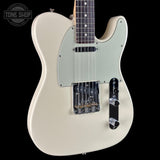 A classic Fender Telecaster electric guitar in a cream finish, shown from a front three-quarter angle against a solid black background. The guitar features a cream-colored body, a matching cream pickguard, and black hardware, with a dark fretboard visible at the top.