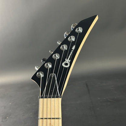 Guitar headstock with brand logo on a gray background