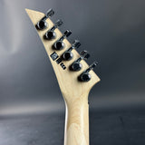 Close-up of a guitar headstock with tuning pegs on a dark background