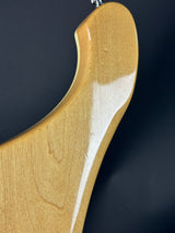 Close-up of a wooden guitar neck with a dark background