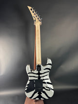 Electric guitar with zebra pattern body on a dark background