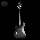 Black electric guitar on a black background with 'Tone Shop' logo.