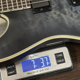 Digital scale displaying weight of a guitar on a wooden surface