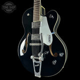 A black Gretsch 6110 electric guitar with gold hardware and a white pickguard, shown against a solid black background. The Tone Shop logo is visible in the top left corner.