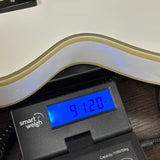 Used Epiphone Inspired by Gibson Les Paul Custom on scale displaying weight.