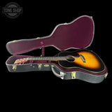 Acoustic guitar in a hard-shell case with 'Tone Shop' logo.