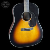Acoustic guitar with a sunburst finish on a black background, featuring the Tone Shop logo.