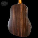 Back view of a wooden acoustic guitar with 'Tone Shop' logo.