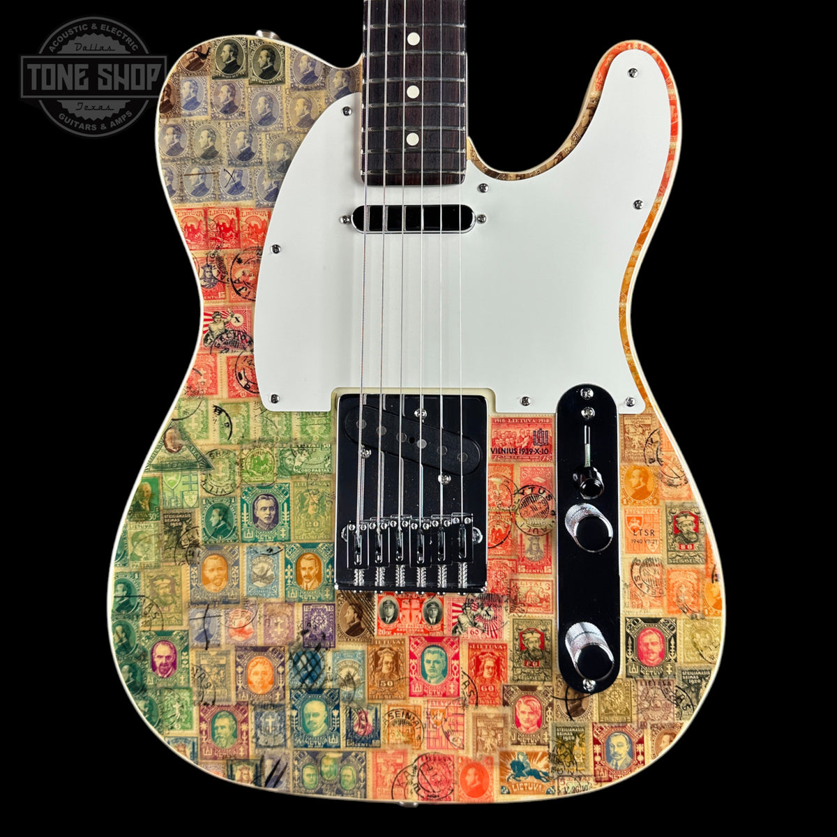 A custom electric guitar with a white pickguard and black hardware, decorated with a vintage postage stamp collage pattern in various colors. The brand 'Tone Shop' is visible as a watermark in the top left corner.