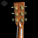 Close-up of a guitar headstock with tuning pegs on a black background, featuring the Tone Shop logo.
