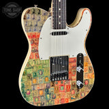 A custom electric guitar with a vintage postage stamp collage pattern on the body, a white pickguard, and chrome hardware, shown against a solid black background with a Tone Shop watermark in the top left corner.