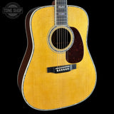 Acoustic guitar with a visible brand logo on a black background