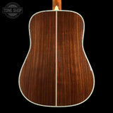 Back view of a wooden acoustic guitar with 'Tone Shop' logo.