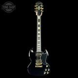 A black Gibson SG electric guitar with gold hardware and white block inlays on the fretboard, shown against a solid black background with a Tone Shop watermark in the top-left corner.