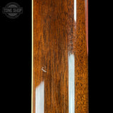 Close-up of a guitar neck with a visible brand logo in the corner.