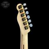 Close-up of the headstock of an electric guitar against a solid black background, showing a light natural wood neck, gold-toned tuning pegs, and white tuning keys. A Tone Shop watermark is visible in the top left corner.