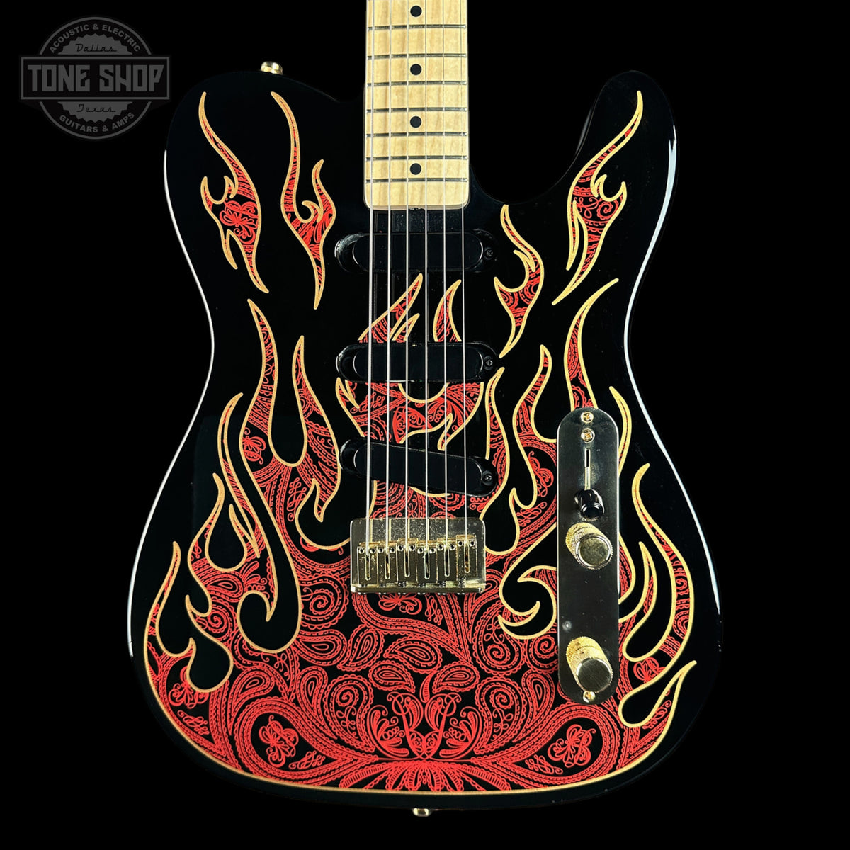 A black electric guitar with a red and gold flame pattern on the body, featuring a maple neck and gold hardware, shown against a black background with a Tone Shop watermark in the top left corner.