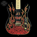 A black electric guitar with a red and gold flame pattern on the body, featuring a maple neck and gold hardware, shown against a black background with a Tone Shop watermark in the top left corner.