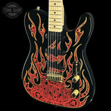A black electric guitar with a custom red and gold flame and scroll pattern on the body, shown against a solid black background with a Tone Shop watermark in the top left corner.